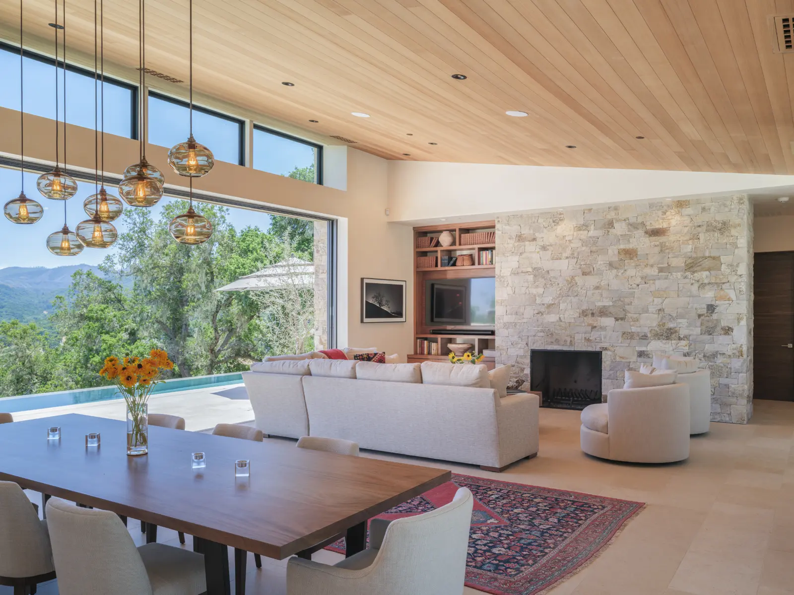 Modern interior with stone fireplace and pool view