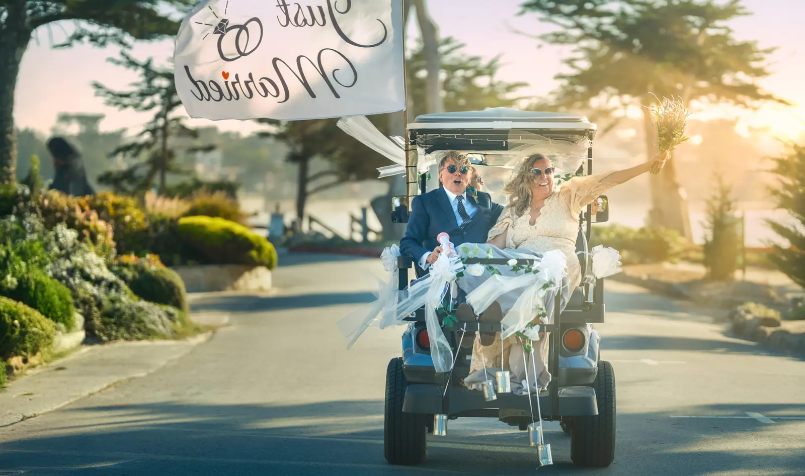 Just-married couple celebrating in a decorated golf cart on Scenic Drive, Carmel-by-the-Sea